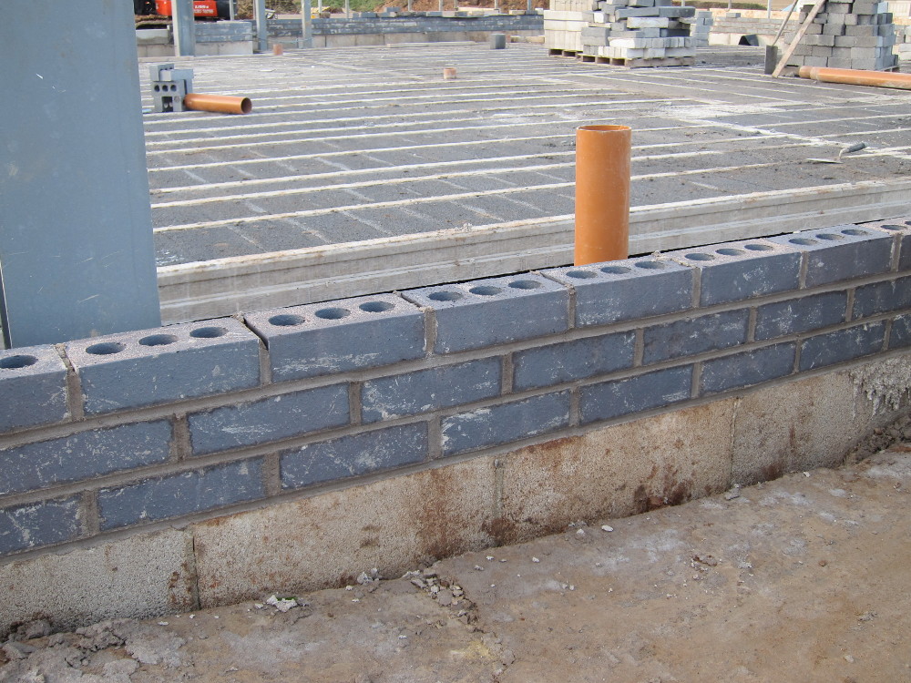 Three courses of "blue" engineering bricks immediately below DPC on the outer cavity wall