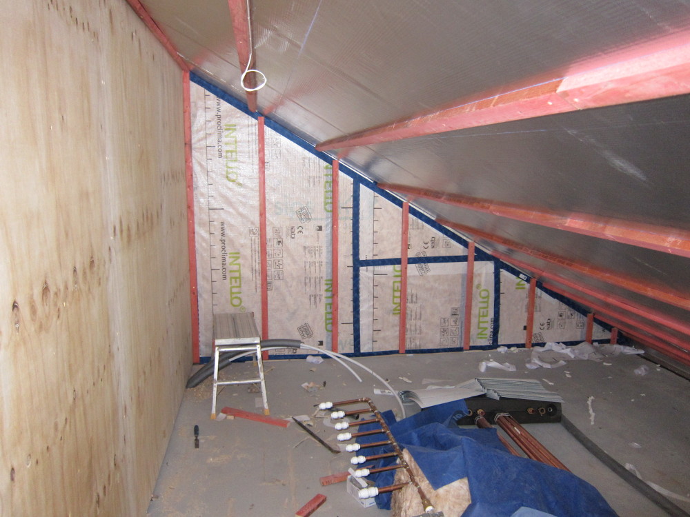 Plant room wall boarded with plywood and taped airtight membrane