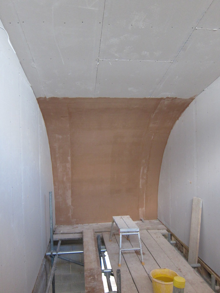 Base coat of plaster on the curved roof over the staircase