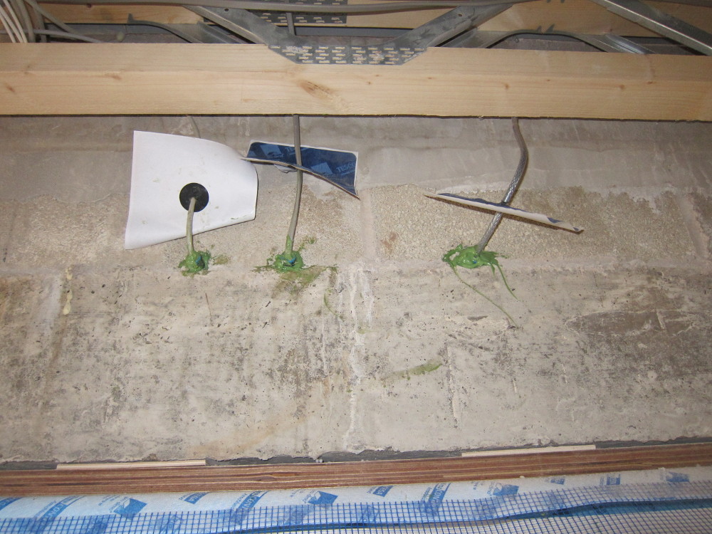 PRO CLIMA ORCON F air-tight adhesive used to seal cable penetrations through wall above front door, with ROFLEX air-tight cable grommets as back-up