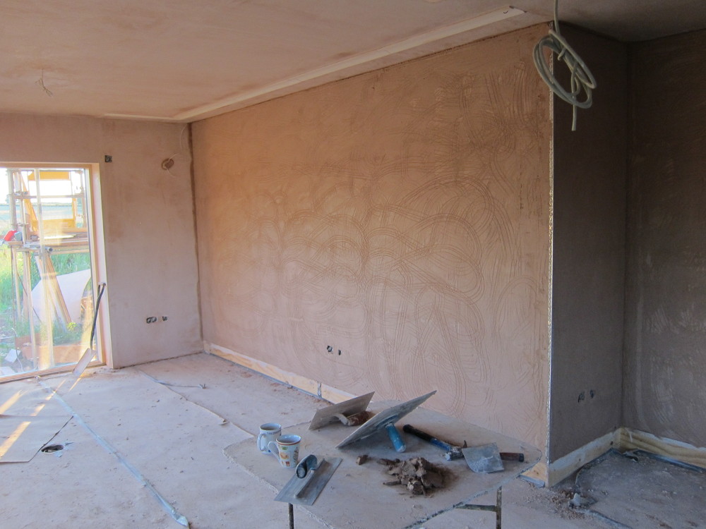 Base ("scratch") plaster coat on one wall in the open plan area