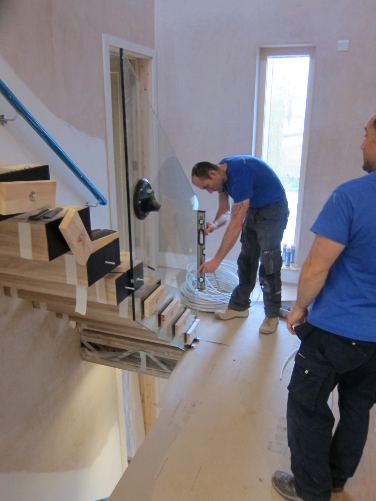 Alvaston Glass installing the first section of glass balustrade on the first-to-second floor staircase